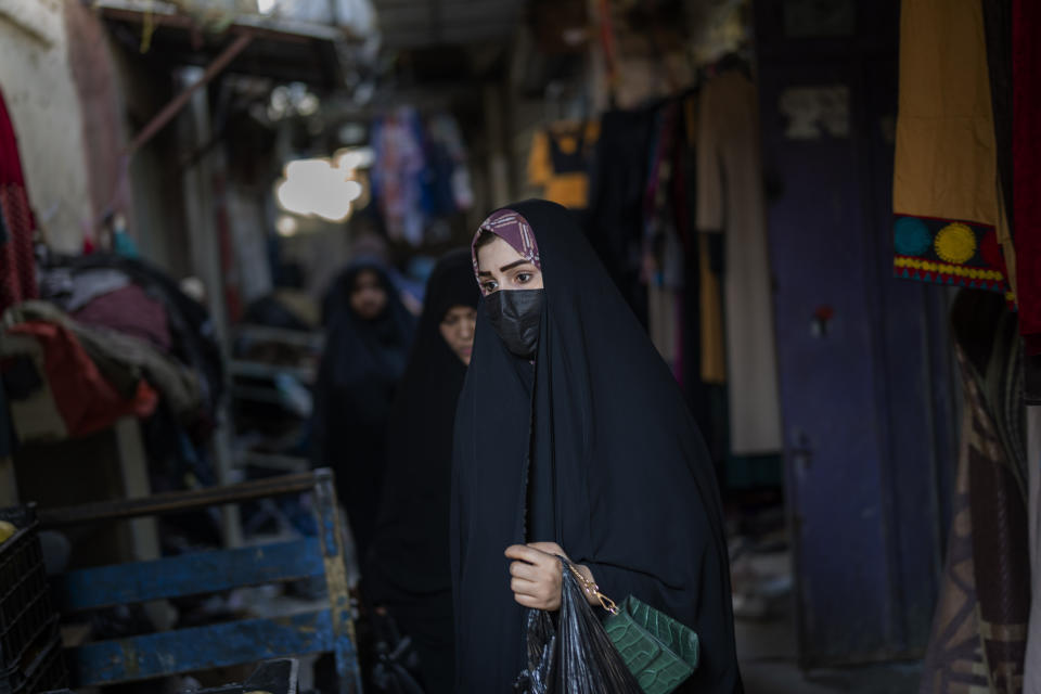 A woman walks through the narrow streets of Alsadria neighborhood in Baghdad, Iraq, Monday, Feb. 27, 2023. For Iraqis, the trauma from the war and U.S. occupation launched twenty years ago is undeniable – an estimated 300,000 Iraqis were killed between 2003 and 2019, according to the Watson Institute for International and Public Affairs at Brown University, as were more than 8,000 U.S. military, contractors and civilians. (AP Photo/Jerome Delay)