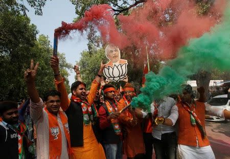 Supporters of Bharatiya Janata Party (BJP) celebrate after learning of the initial poll results outside the party headquarters in New Delhi, India, March 11, 2017. REUTERS/Adnan Abidi