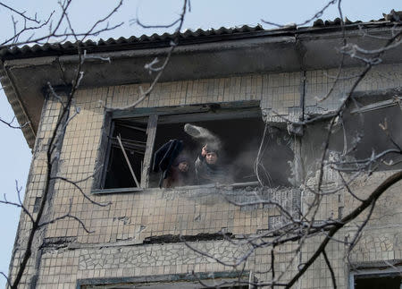 Local residents are seen in REUTERS/Gleb Garanich a building which was damaged during fighting between the Ukrainian army and pro-Russian separatists in the government-held industrial town of Avdiyivka, Ukraine. The Moscow-backed rebels and government forces trade blame for the flare-up in the industrial east that has caused the highest casualty rate since mid-December and cut off power and water to thousands of civilians on both sides of the front line.