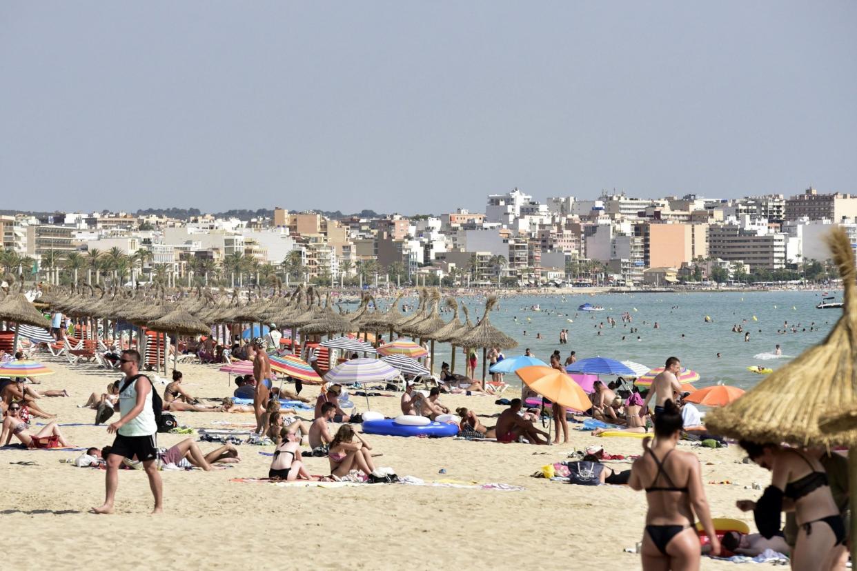 Sunseekers: Holidaymakers on the beach in Palma, Majorca: EPA