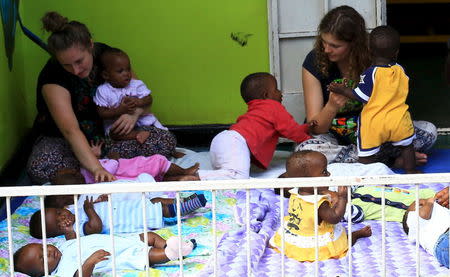 Local and foreign volunteers play with abandoned babies at children at a home in Uganda's capital, Kampala May 14, 2015. REUTERS/James Akena