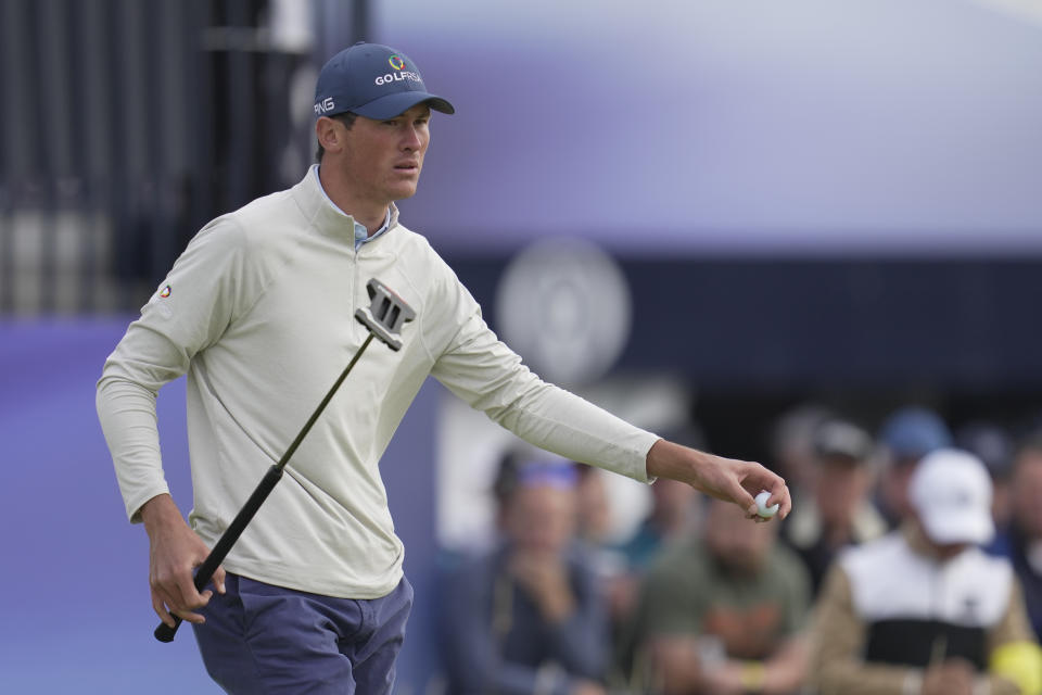 South Africa's Christo Lamprecht (amateur) picks up his ball on the 3rd green on the first day of the British Open Golf Championships at the Royal Liverpool Golf Club in Hoylake, England, Thursday, July 20, 2023. (AP Photo/Kin Cheung)