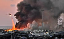 A helicopter puts out a fire at the scene of an explosion at the port of Lebanon's capital Beirut on August 4, 2020. (Photo by STR / AFP) (Photo by STR/AFP via Getty Images)