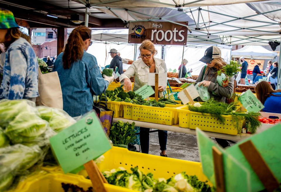 People shop for produce at the McClendon's Select stand at the Old Town Scottsdale Farmers Market on March 28, 2020.