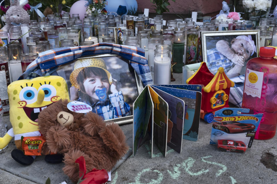 Photos, candles, flowers and balloons are placed as a memorial for three children who were killed at the Royal Villa apartments complex in the Reseda section of Los Angeles, on Monday, April 12, 2021. Authorities have identified 3-year-old Joanna Denton Carrillo, her 2-year-old brother, Terry, and 6-month-old sister, Sierra, as the three young children who were killed over the weekend. Their mother is the suspect in their deaths and was being held in a central California jail. (AP Photo/Richard Vogel)