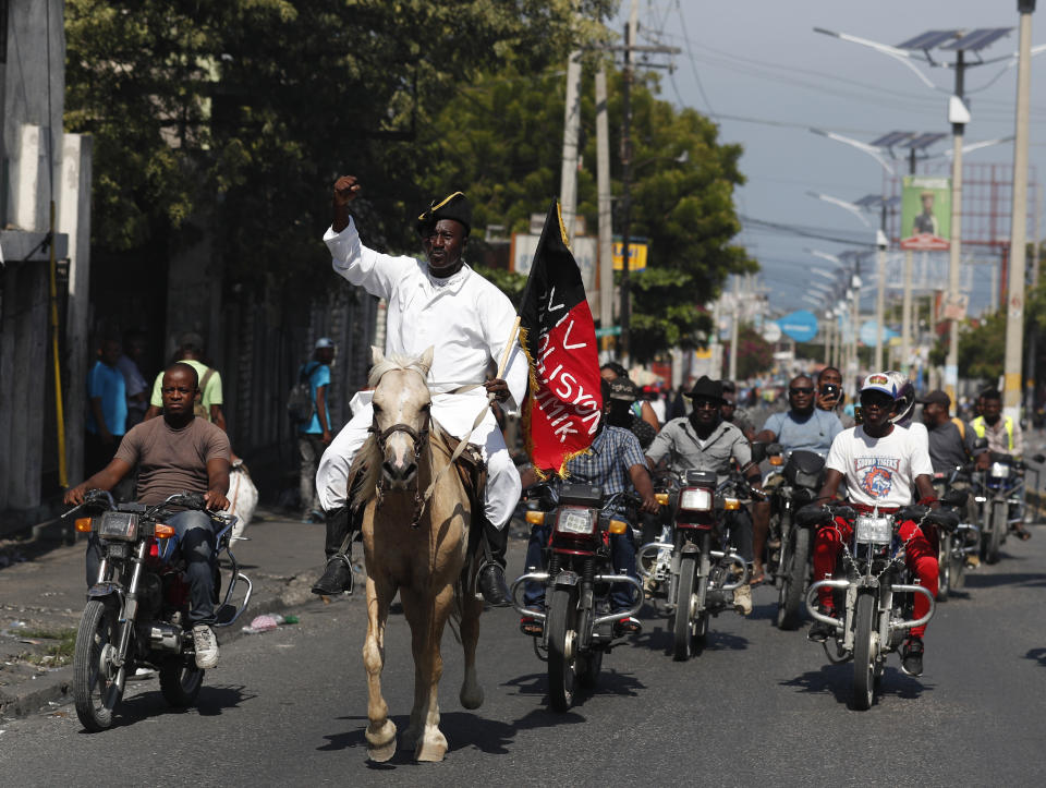 Jean Marcellis Destine, dressed as an independence hero, rides a horse before a protest calling for the resignation of President Jovenel Moise, in Port-au-Prince, Haiti, Friday, Oct. 4, 2019. After a two-day respite from the recent protests that have wracked Haiti's capital, opposition leaders urged citizens angry over corruption, gas shortages, and inflation to join them for a massive protest march to the local headquarters of the United Nations.(AP Photo/Rebecca Blackwell)