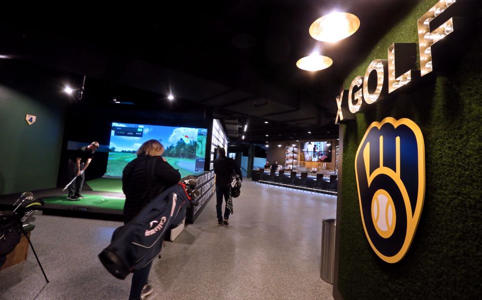 Golfers arrive at the X-Golf America simulator at American Family Field.