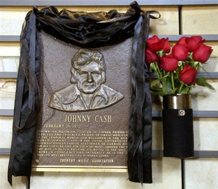 The hall of fame brass plaque honoring country music singer Johnny Cash is draped in black with red roses at the side at the County Music Hall of Fame and Museum in Nashville, Tennessee, September 12, 2003.