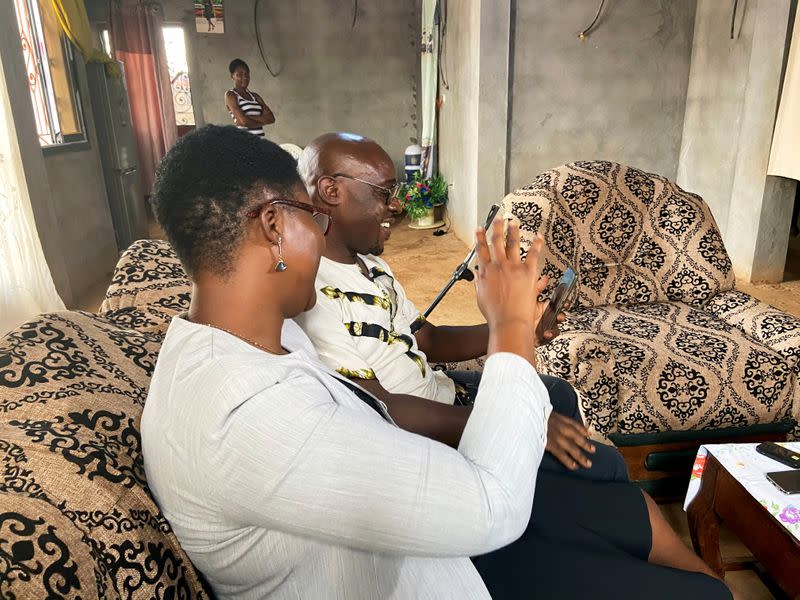 Roger Michel Kemkuining, a teacher in an electrical engineering school, holds a video call with his son, Pavel Daryl Kem, 21, a student who is infected with the coronavirus in China as he sits with his wife Albertine at their house in Douala