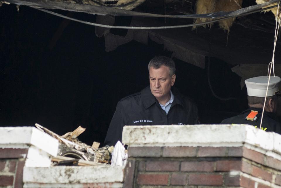 New York Mayor Bill de Blasio surveys the aftermath of a home fire in the Midwood neighborhood of Brooklyn, New York March 21, 2015. In one of New York City's deadliest fires in years, seven children from the same Orthodox Jewish family died early on Saturday when flames ripped through their Brooklyn home, officials said. The blaze, which erupted just before 12:30 a.m. (0430 GMT), appeared to have been started accidentally by a hot plate, which are used by many Orthodox families to warm food on the Sabbath, said Fire Commissioner Daniel Nigro. REUTERS/Stephanie Keith