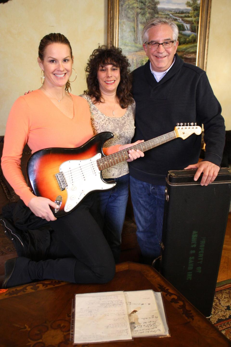 This undated image released by PBS shows, from left, Elyse Luray, contributor Dawn Peterson and Wes Cowan, from "History Detectives" with Bob Dylan's guitar. The electric guitar that Bob Dylan plugged in at the Newport Folk Festival in 1965 may be the most historic instrument in rock music, and it has sat mostly unnoticed in a New Jersey attic for most of the 47 years since. Dylan left it behind in an airplane and it was taken home by the pilot. The late pilot's daughter recently took it to PBS' "History Detectives," who authenticated the potentially fortune-making find in an episode that will air starting next Tuesday, July 17. (AP Photo/PBS, Tom McNamara)