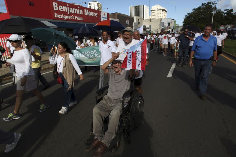 FILE PHOTO: People take part in a march to improve healthcare benefits in San Juan, Puerto Rico