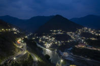 Confluencia de los ríos Alaknanda y Bhairathi que representa el nacimiento del Ganges, iluminada de noche en la ciudad de Devprayag, India, el 13 de mayo del 2019. (AP Photo/Altaf Qadri)