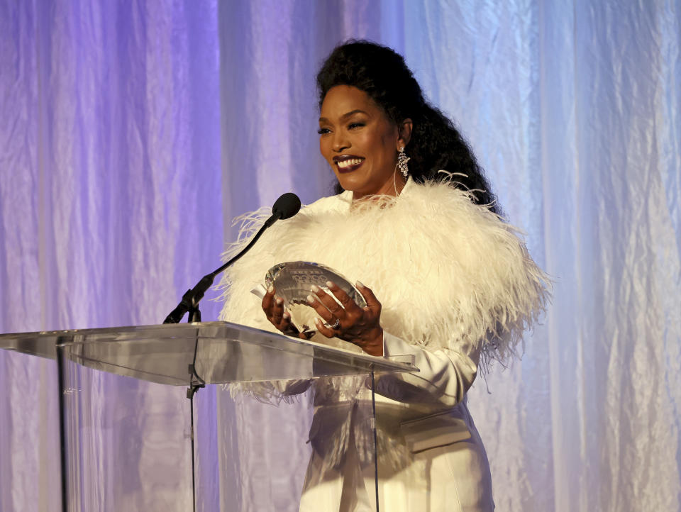 <p>Dressed in a white ensemble — complete with feathers —Angela Bassett accepts the award for best supporting actress for her performance in <em>Black Panther: Wakanda Forever</em> at the 14th Annual AAFCA Awards in Beverly Hill. </p>