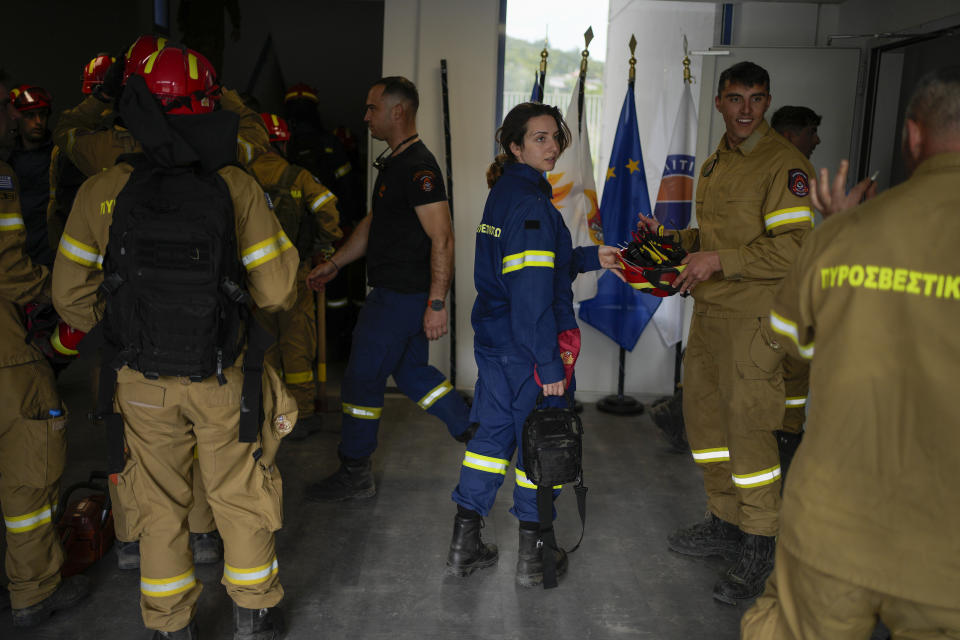 Firefighters in training for the special unit with the yellow uniforms, gather after a practice at the Civil Protection Academy in Villia village some 60 kilometers (37 miles) northwest of Athens, Greece, Friday, April 19, 2024. Greece's fire season officially starts on May 1 but dozens of fires have already been put out over the past month after temperatures began hitting 30 degrees Celsius (86 degrees Fahrenheit) in late March. This year, Greece is doubling the number of firefighters in specialized units to some 1,300, adopting tactics from the United States to try and outflank fires with airborne units scrambled to build breaks in the predicted path of the flames. (AP Photo/Thanassis Stavrakis)