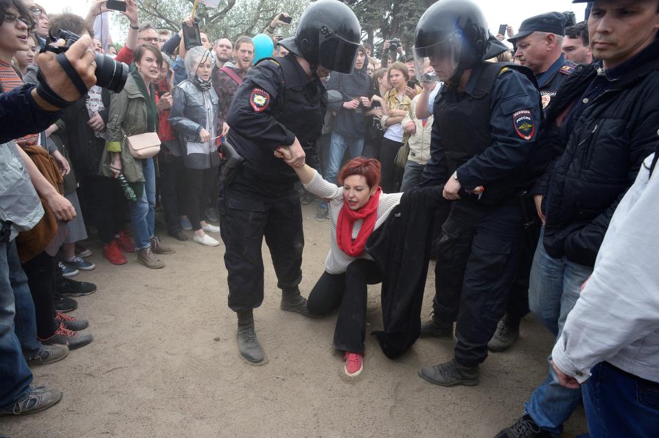 Riot police officers detain a participant of an opposition rally.