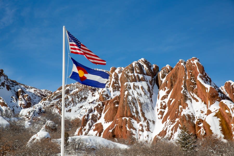 US flag in front of red rock formation at Roxborough State Park in Colorado