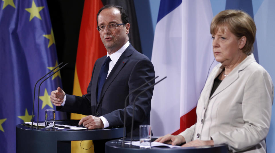 German Chancellor Angela Merkel, right, and the President of France, Francois Hollande, left, address the media after a meeting at the chancellery in Berlin, Germany, Tuesday, May 15, 2012. (AP Photo/Michael Sohn)