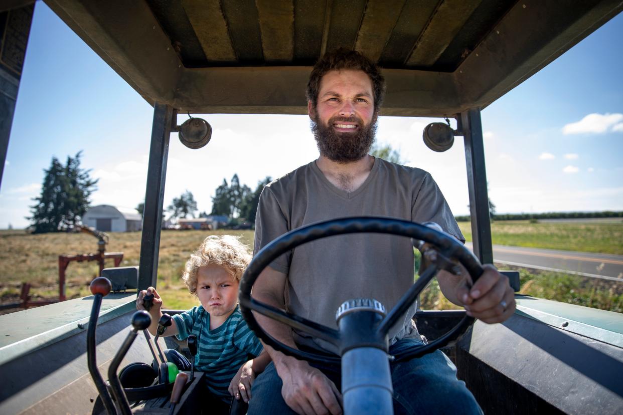 James, de 3 años, y Graham Fordyce viajan en el tractor después de instalar el riego en Fordyce Farm el 13 de julio en Salem.