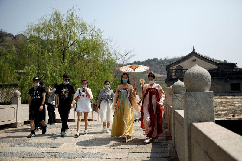 Women wearing face masks and traditional Chinese clothing visit Gubei Water Town on the first day of the five-day Labour Day holiday, following the coronavirus disease (COVID-19) outbreak, on the outskirts of Beijing