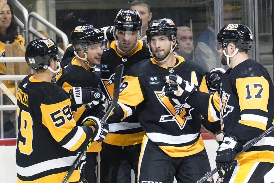 Pittsburgh Penguins' Evgeni Malkin (71) celebrates with Bryan Rust (17), Kris Letang (58), Sidney Crosby (87) and Jake Guentzel (59) after scoring against the Arizona Coyotes during the second period of an NHL hockey game Thursday, Oct. 13, 2022, in Pittsburgh. (AP Photo/Keith Srakocic)
