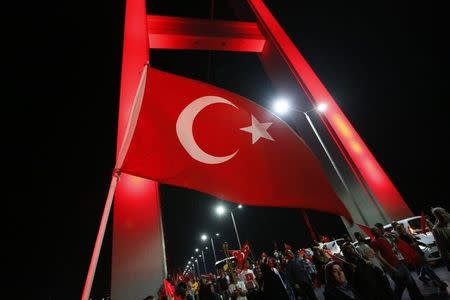 A Turkish national flag waves as pro-government demonstrators march over the Bosphorus Bridge, from the Asian to the European side of Istanbul, Turkey, July 21, 2016. REUTERS/Murad Sezer