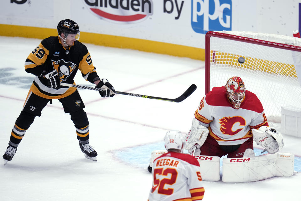 Pittsburgh Penguins' Jake Guentzel (59) can't get a shot past Calgary Flames goaltender Jacob Markstrom (25) during the first period of an NHL hockey game in Pittsburgh, Saturday, Oct. 14, 2023. (AP Photo/Gene J. Puskar)
