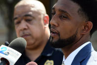 Baltimore Mayor Brandon Scott speak during a news conference as Police Commissioner Michael Harrison, left, listens, Wednesday, June 16, 2021, in Baltimore. One person was killed and five others were wounded Wednesday when gunmen walked up a street and opened fire on a Baltimore block from an intersection, the city's police commissioner said. (Kim Hairston/The Baltimore Sun via AP)