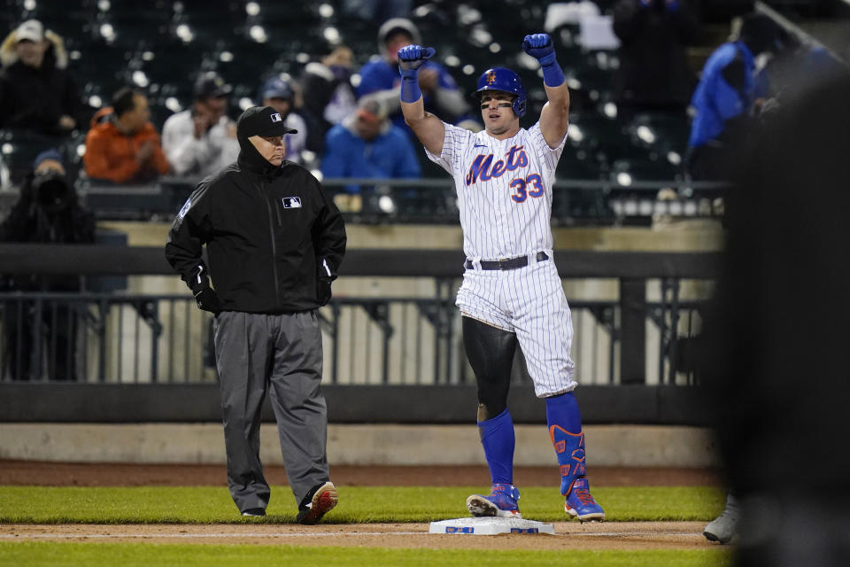 New York Mets' James McCann (33) gestures to teammates after hitting a double and advancing to third on an error during the third inning of the team's baseball game against the Atlanta Braves on Saturday, May 29, 2021, in New York. (AP Photo/Frank Franklin II)