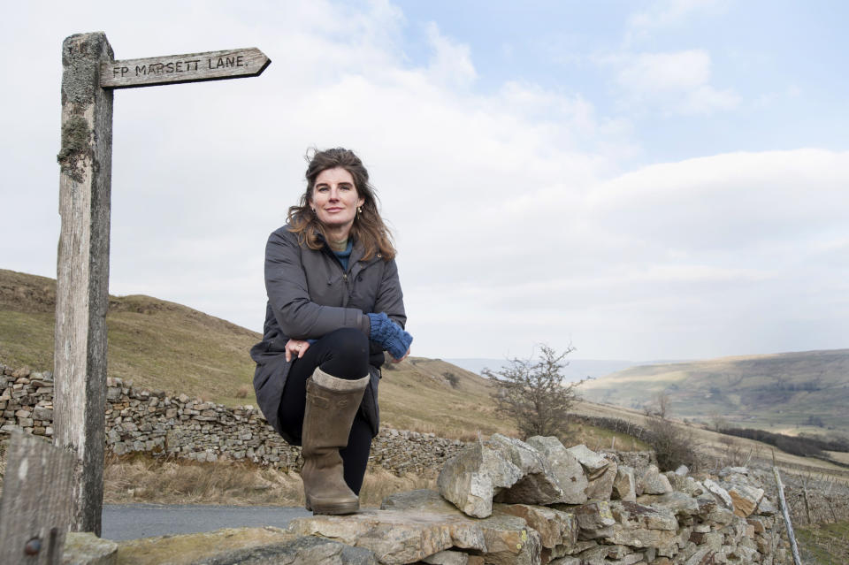 Programme Name: Winter Walks S2 - TX: 29/11/2021 - Episode: Winter Walks S2 - Amanda Owens (No. Amanda Owens) - Picture Shows: by a drystone wall next to the Marsett Lane footpath sign. Amanda Owens - (C) Tim Smith - Photographer: Tim Smith