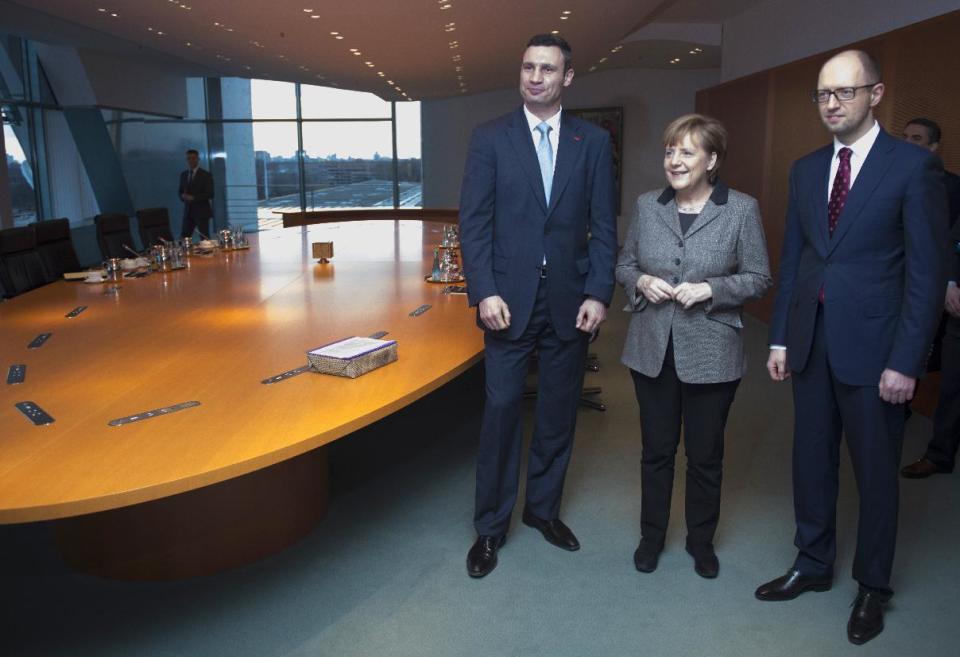 German Chancellor Angela Merkel, center, welcomes Ukraine opposition leaders Vitali Klitschko, left, and Arseniy Yatsenyuk, right, Monday, Feb. 17, 2014 at the chancellery in Berlin to discuss the country's crisis. The former Soviet nation has been in chaos since November when President Viktor Yanukovych ditched a planned EU trade and political pact in favor of closer ties with Moscow. (AP Photo/Jogannes Eisele, Pool)