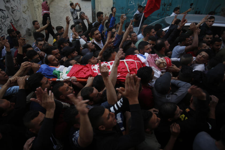 Palestinian mourners carry the body of Omar Badawi, 22, during his funeral at the al-Arroub refugee camp in the West Bank city of Hebron, Monday, Nov. 11, 2019. Badawi was shot in the chest during the confrontation with Israeli forces in the Aroub refugee camp, near the city of Hebron, on Monday afternoon. It gave no further details.(AP Photo/Majdi Mohammed)