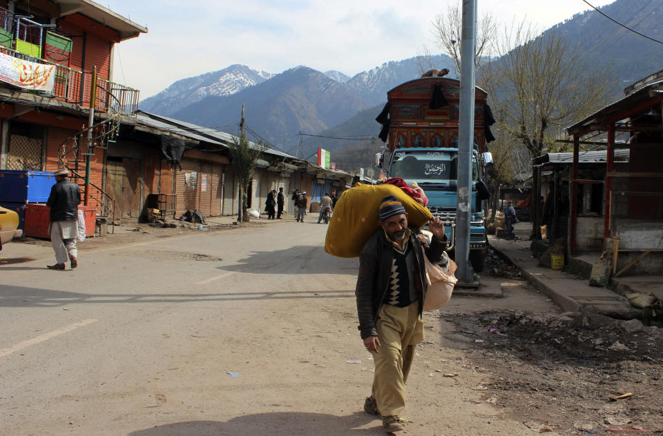 A Pakistani Kashmiri carries his belonging and walks through a market at his hometown in Chakoti on the violent border that separates the Himalayan region of Kashmir between Pakistan and India, Saturday, March 2, 2019. Indian and Pakistani soldiers again targeted each other's posts and villages along their volatile frontier in disputed Kashmir, killing at some civilians and wounding few others, officials said. b(AP Photo/Roshan Mughal)