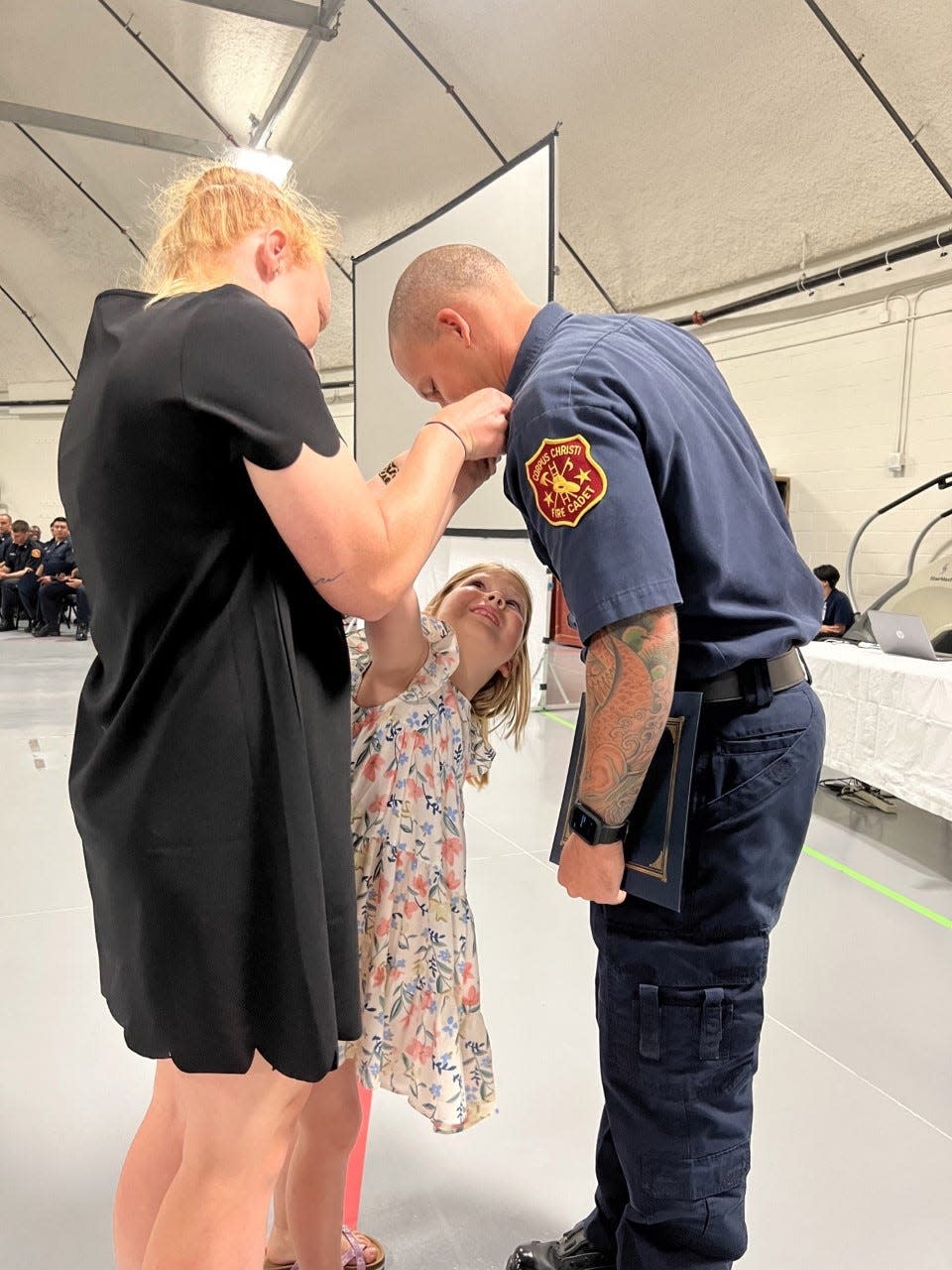 Corpus Christi Fire Department cadet Donovan Dillon is pinned by his wife, Lauren Dillon, and daughter, Rowan Dillon, during a ceremony Thursday, May 12, 2022, at Del Mar College.