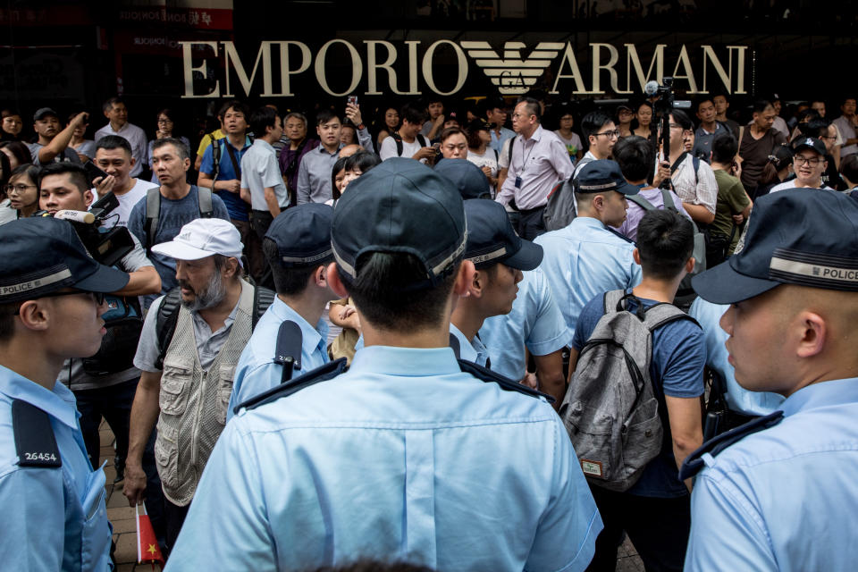 HONG KONG, CHINA - SEPTEMBER 18: Pro-Democracy supporters (back) shout slogans as police help to escort a small number of pro-China supporters away, after they tried to hold a march outside a shopping mall on September 18, 2019 in Hong Kong, China. Pro-democracy protesters have continued demonstrations across Hong Kong, calling for the city's Chief Executive Carrie Lam to immediately meet the rest of their demands, including an independent inquiry into police brutality, the retraction of the word “riot” to describe the rallies, and genuine universal suffrage, as the territory faces a leadership crisis. (Photo by Chris McGrath/Getty Images)