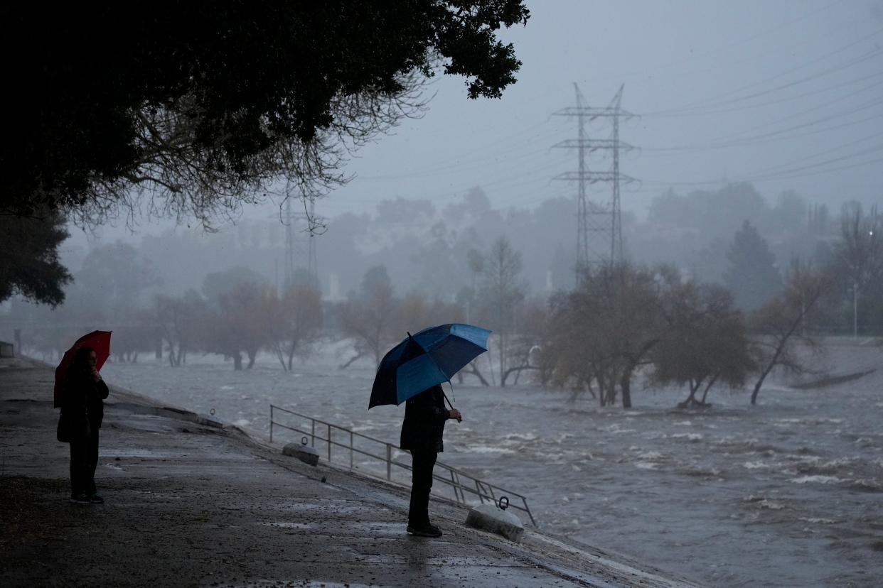 Two people look on at floodwaters in California (Copyright 2024 The Associated Press. All rights reserved)