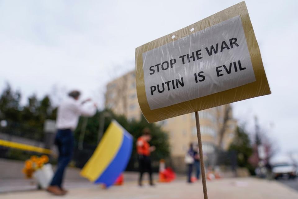 A sign that reads “STOP THE WAR PUTIN IS EVIL” is seen as supporters of Ukraine demonstrate with the yellow and blue flag of Ukraine in front of the Embassy of Russian Federation in Washington. (AP Photo/Carolyn Kaster/PA)) (AP)