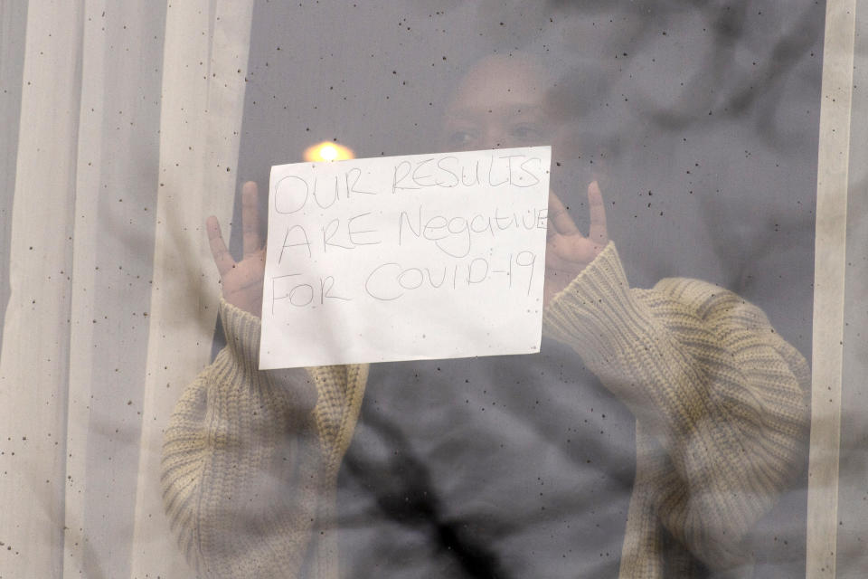 <p>LONDON, UNITED KINGDOM - FEBRUARY 16: A traveller staying at the The Raddison Blu Edwardian Hotel holds a hand written sign against her room window after being quarantined in London, United Kingdom on February, 16, 2021. All travellers arriving in England from 33 high-risk countries will be required to quarantine in a hotel for 10 days. (Photo by Ray Tang/Anadolu Agency via Getty Images)</p>
