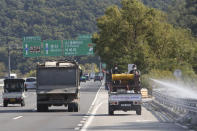 Disinfectant solution is sprayed from a vehicle as a precaution against African swine fever on the road in Paju, South Korea, near the border with North Korea, Tuesday, Oct. 15, 2019. Amid swine fever scare that grips both Koreas, South Korea is deploying snipers, installing traps and flying drones along the rivals' tense border to kill wild boars that some experts say may have spread the animal disease from north to south. (AP Photo/Ahn Young-joon)