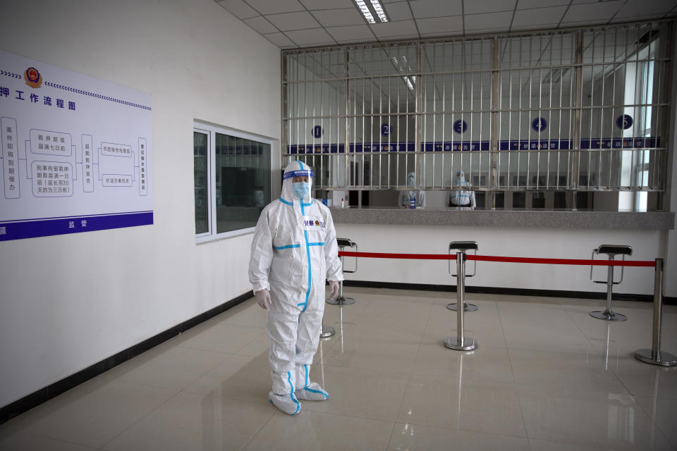 A security officer in a protective suit stands in a reception area at the visitors' hall at the Urumqi No. 3 Detention Center in Dabancheng in western China's Xinjiang Uyghur Autonomous Region on April 23, 2021. State officials took AP journalists on a tour of a "training center" turned detention site in Dabancheng sprawling over 220 acres and estimated to hold at least 10,000 prisoners - making it by far the largest detention center in China and among the largest on the planet. (AP Photo/Mark Schiefelbein)