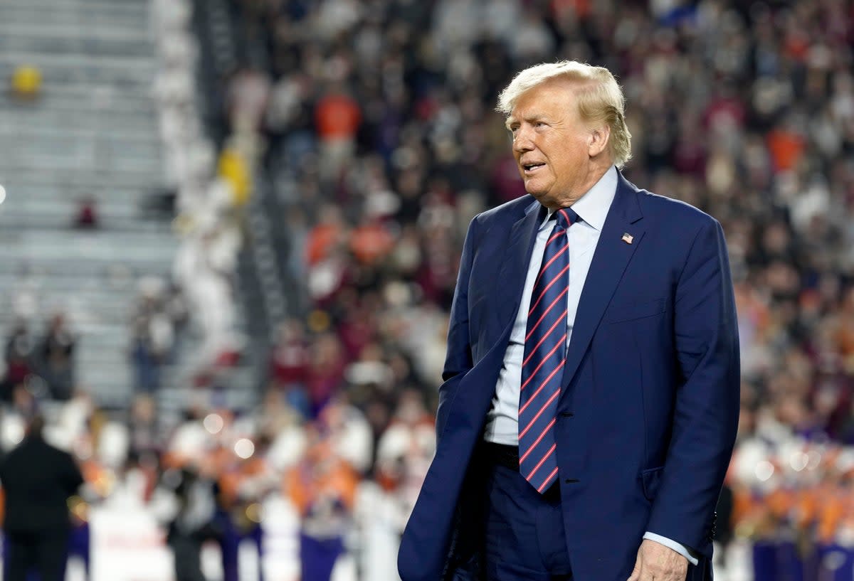 Republican presidential candidate and former President Donald Trump stands on the field during halftime in an NCAA college football game between the University of South Carolina and Clemson Saturday, 25 November 2023, in Columbia, South Carolina  (AP)