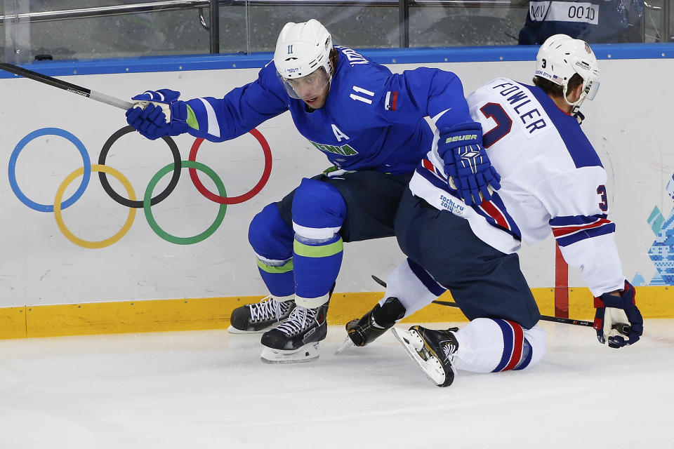 Slovenia forward Anze Kopitar collides with USA defenseman Cam Fowler during the 2014 Winter Olympics men's ice hockey game at Shayba Arena Sunday, Feb. 16, 2014, in Sochi, Russia. USA defeated Slovenia 5-1. (AP Photo/Petr David Josek)