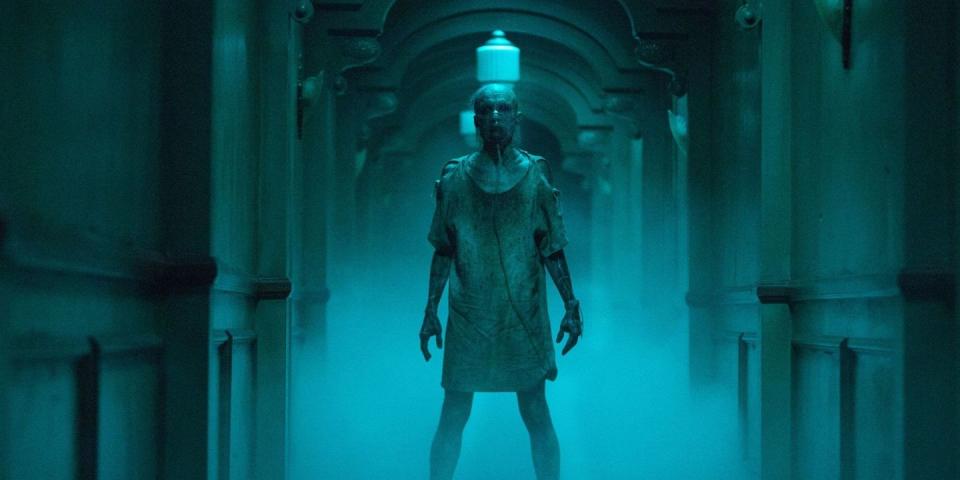 a demon known as the man who can't breath stands in a hallway in a scene from insidious chapter 3