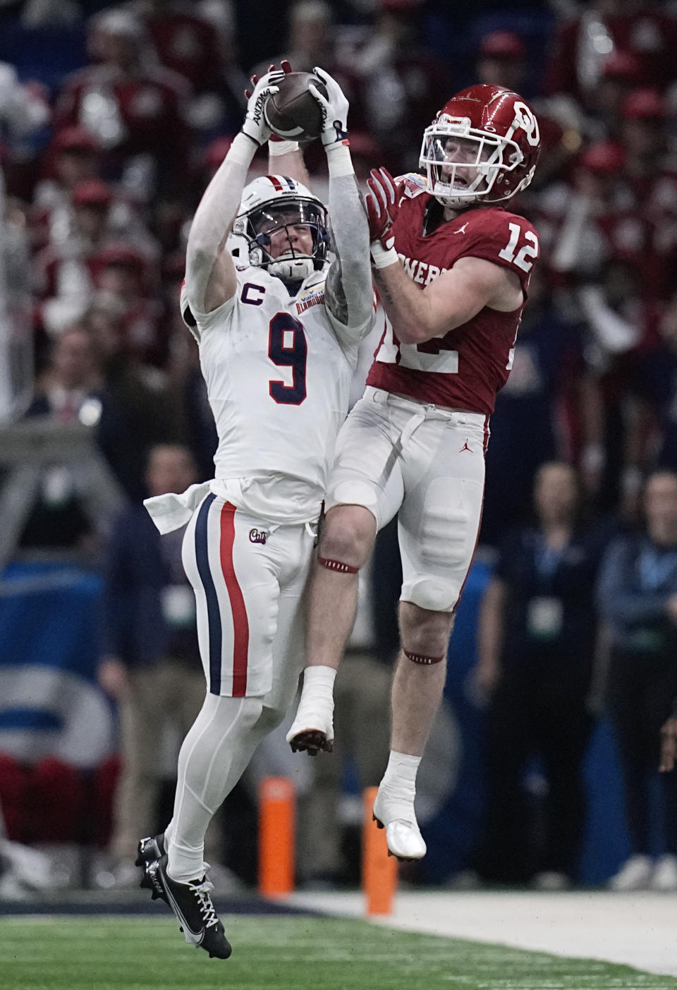 Arizona safety Gunner Maldonado (9) intercepts a pass intended for Oklahoma wide receiver Drake Stoops (12) during the first half of the Alamo Bowl NCAA college football game in San Antonio, Thursday, Dec. 28, 2023. (AP Photo/Eric Gay)