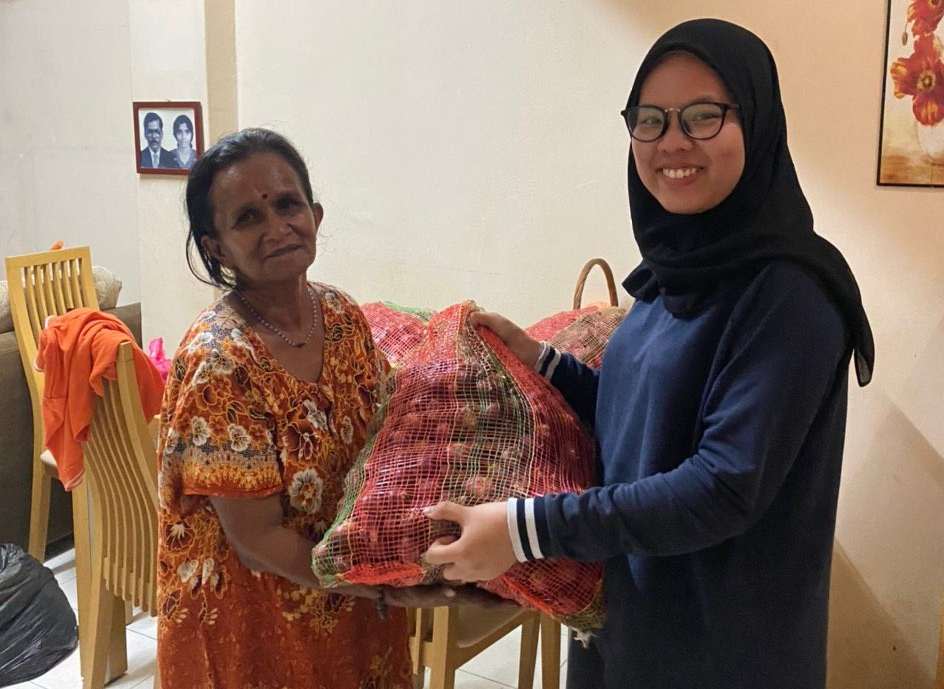 Roob Ganesan's friend, Adibah Atiqah, giving Mahamachumy a sack of onions to be peeled August 4, 2020. — Picture courtesy of Roob Ganesan