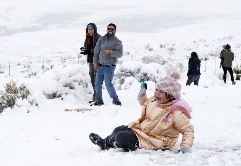Valentina Gonzalez, 7, laughs after falling during a snowball fight with her family at the Red Rock Canyon National Conservation, west of Las Vegas Thursday, Feb. 21, 2018. In the background is her father Omar Gonzalez and her brother Omar Jr. (Steve Marcus/Las Vegas Sun via AP)
