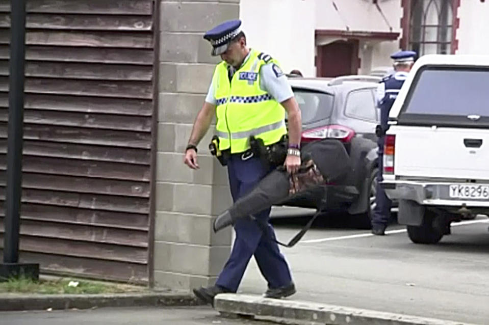 In this image made from video taken March 19, 2019, a police officer carries a gun voluntarily surrendered by a member of the public into the Masterton police station in Masterton, New Zealand. Prime Minister Jacinda Ardern says New Zealand is immediately banning sales of "military-style" semi-automatic and automatic weapons like the weapons used in last Friday's attacks on two Christchurch mosques. (TVNZ via AP)