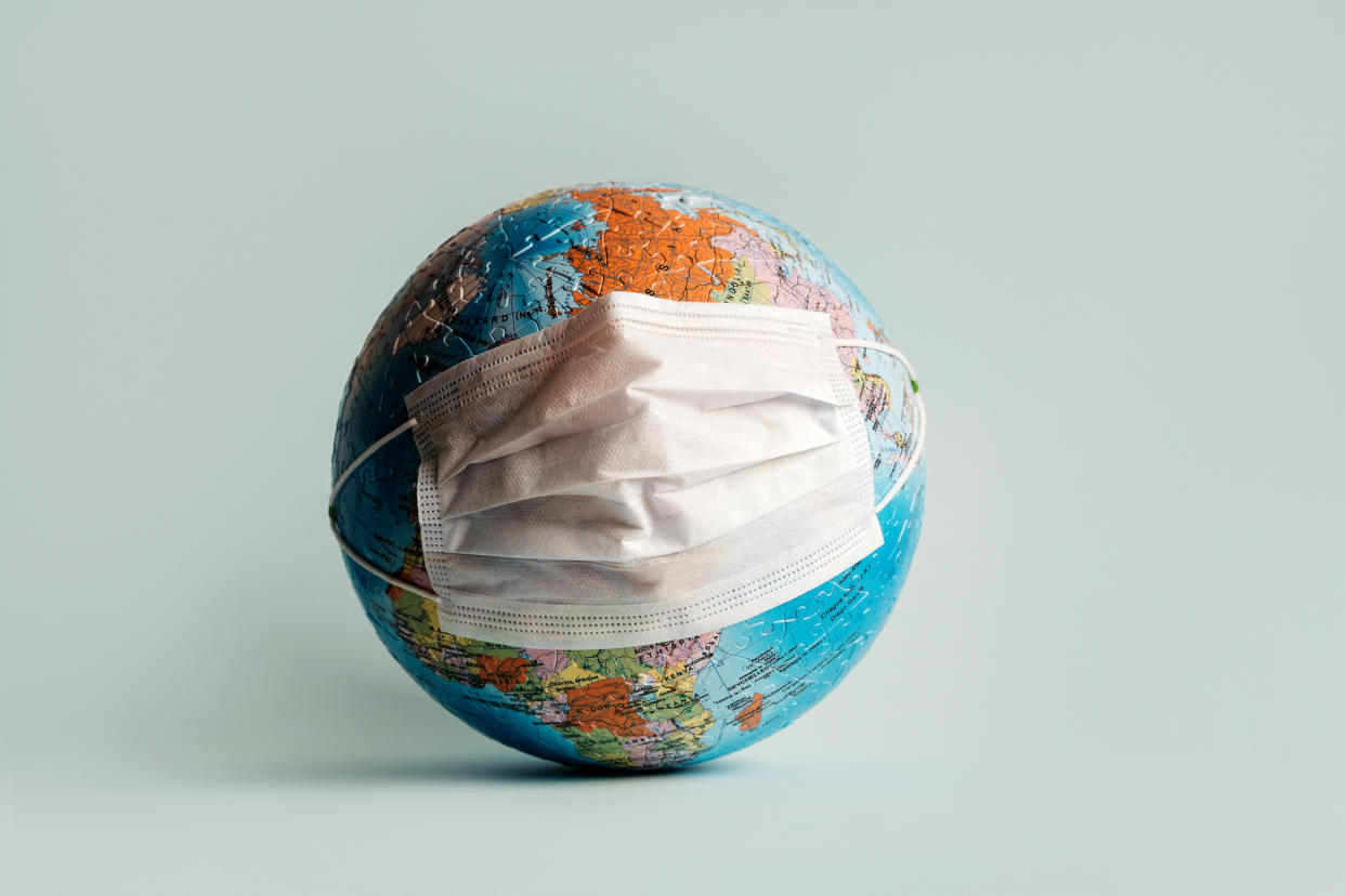 Globe made of jigsaw puzzles with a mask