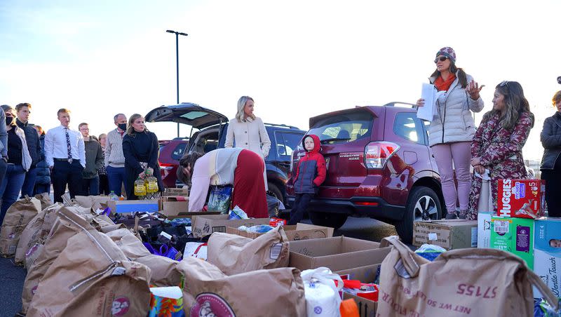 Jennifer Hua address a group of volunteers in a shopping center parking lot in Midvale on Sunday Dec. 5, 2021, as they pack boxes with supplies to deliver to newly arrived Afghan families.