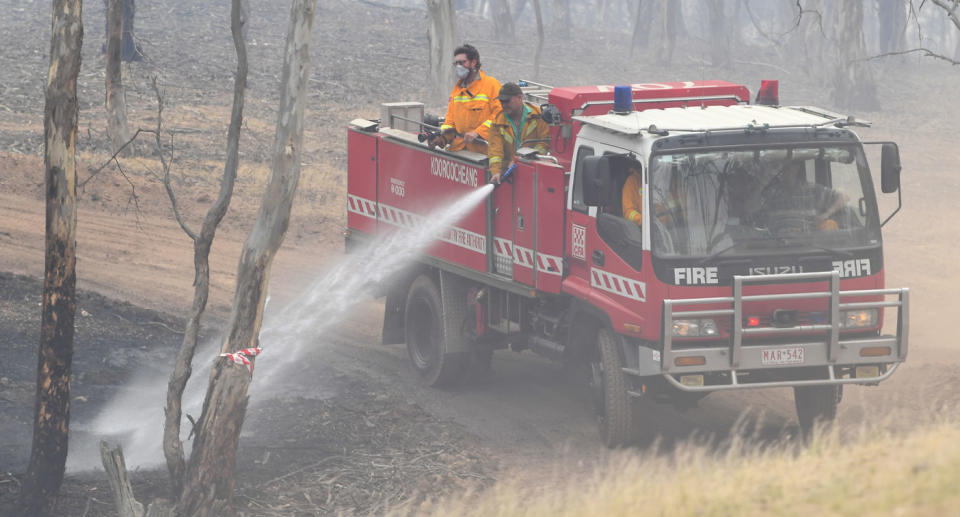 Fire crews douse burning land with fire hoses in Mount Glasgow in Victoria.